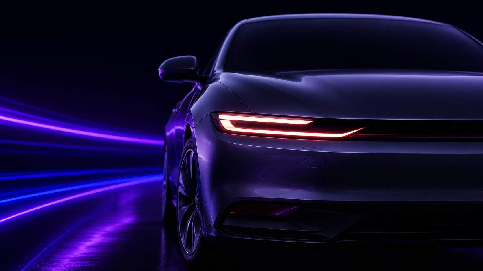 The front of a dark electric car, its light bar lit, on a black road