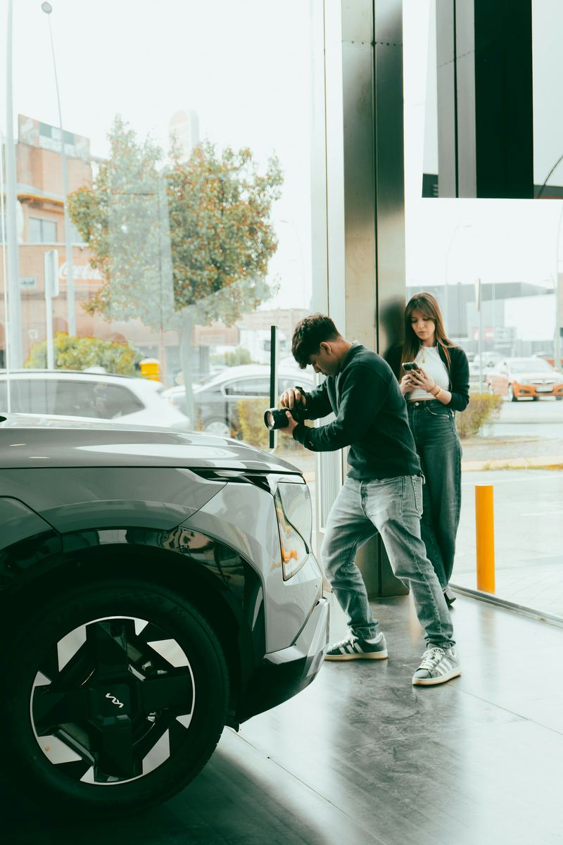 An inspector photographing an electric car during a check